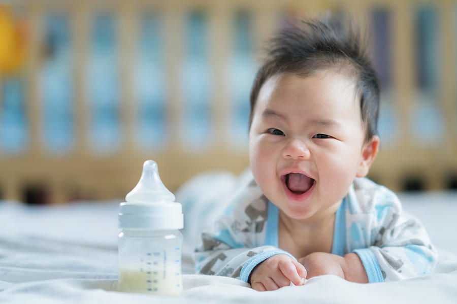 Asian Newborn baby smile with milk power bottle Photograph by Anek  Suwannaphoom