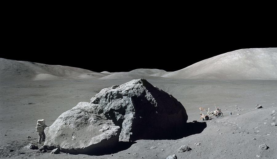 Astronaut on spacewalk on lunar surface near large rock with moon rover at right Painting by Celestial Images