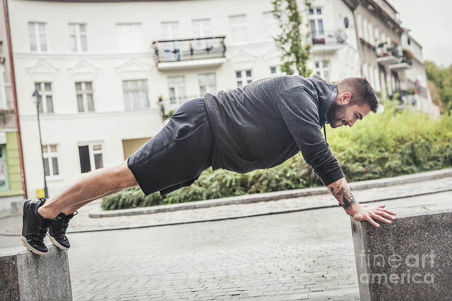 Athletic man training on a street. Photograph by Michal Bednarek