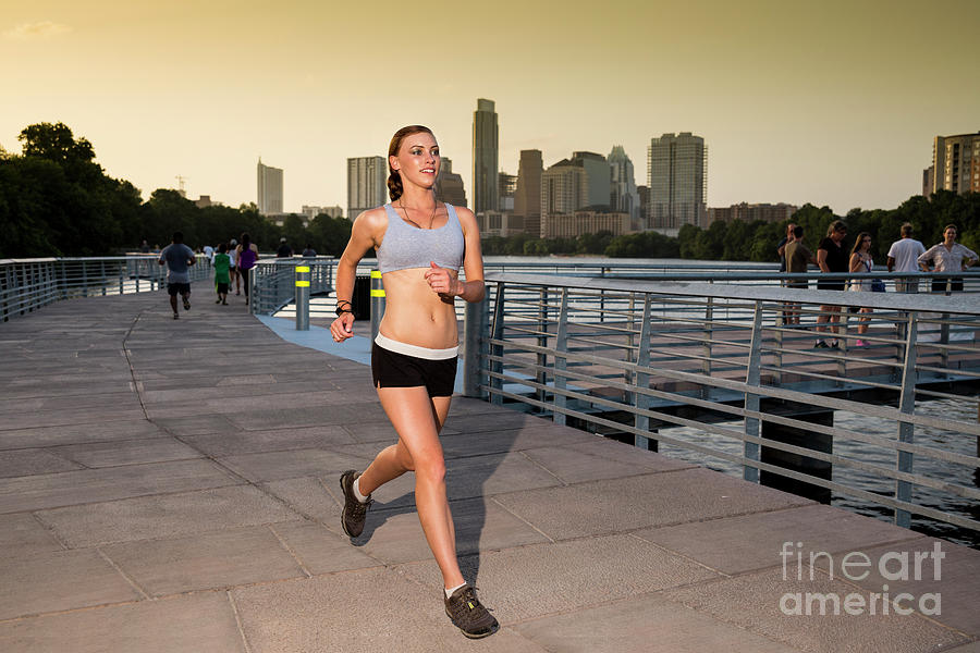 Austin Skyline Photograph - Athletic woman running jogging outside on the the Boardwalk Trail along Lady Bird Lake in downtown Austin, Texas by Dan Herron