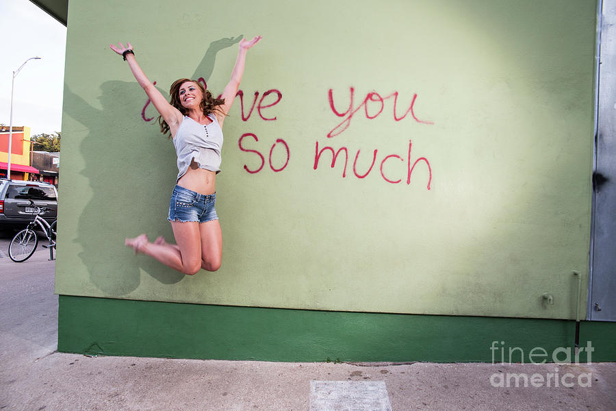 I Love You So Much Photograph - Attractive Austin local woman jumps for joy at the i love you so much mural  by Dan Herron