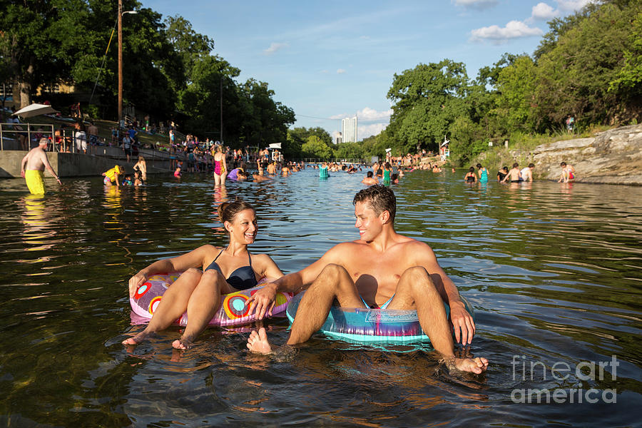 Austin Photograph - Attractive smiling couple floating on inner tube at Barton Sprin by Dan Herron
