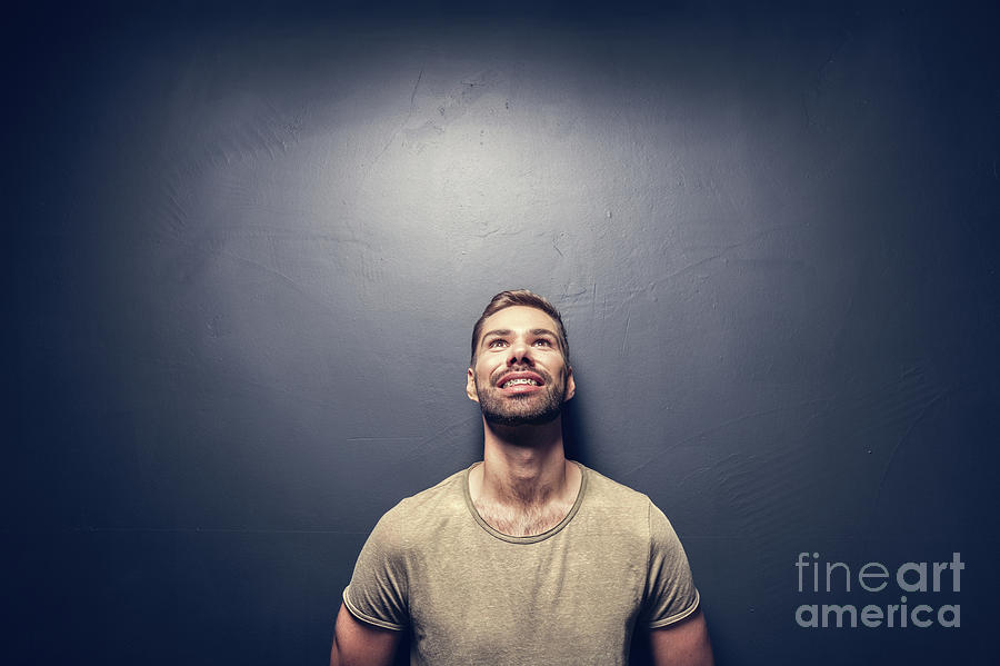 Attractive, smiling man leaning against the wall. Photograph by Michal Bednarek