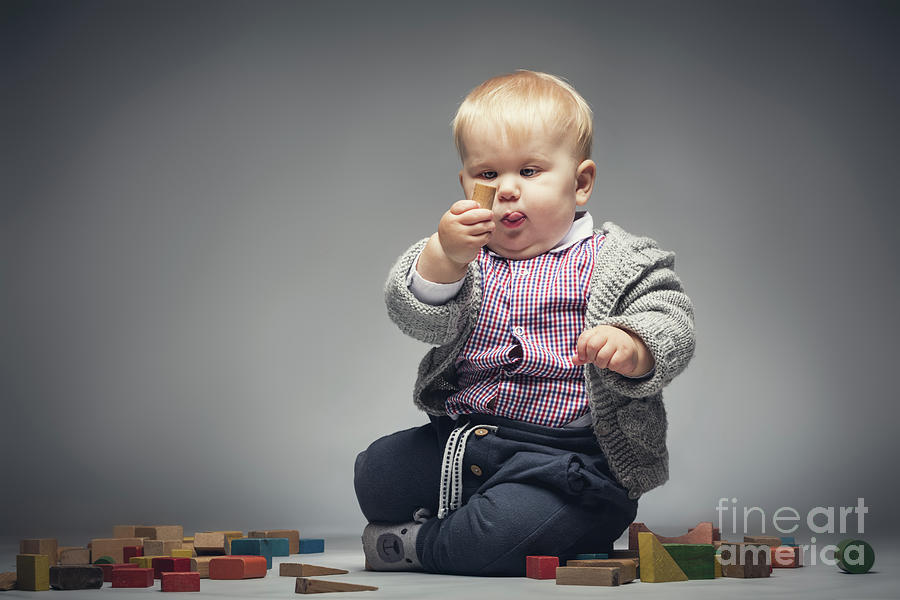 Baby boy examining a building block. Photograph by Michal Bednarek