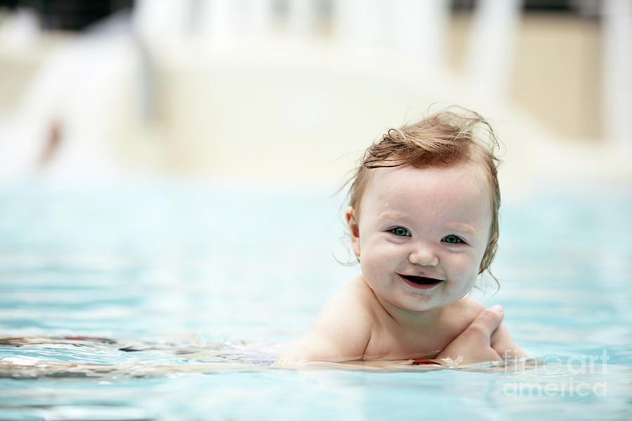 Baby girl swimming in a pool. Photograph by Michal Bednarek