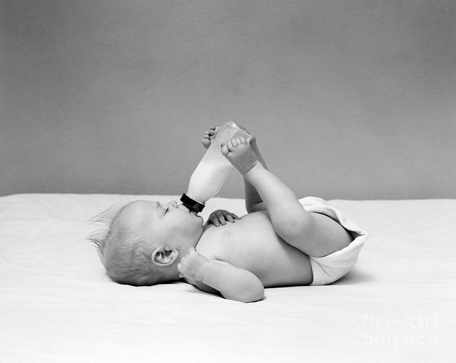 Vintage Photograph - Baby Holding Milk Bottle With Feet by H. Armstrong Roberts/ClassicStock
