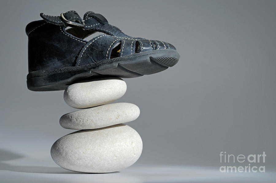Scale Photograph - Baby shoe on stack of pebbles by Sami Sarkis