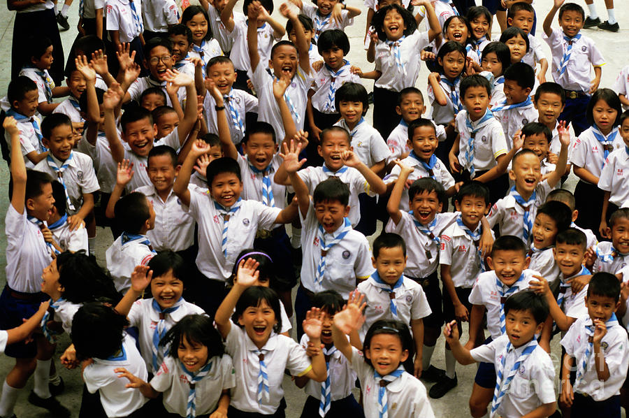 Bangkok school children jumping and smiling at the camera Photograph by Sami Sarkis