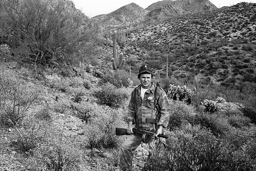Barry Sadler with two of his machine guns in the desert Tucson Arizona 1971 Photograph by David Lee Guss