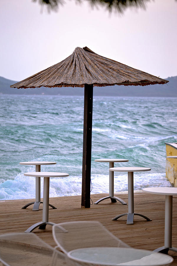 Beach bar parasol by rough sea Photograph by Brch Photography