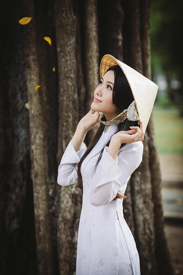 Beautiful Vietnamese women with ao dai and non la Photograph by