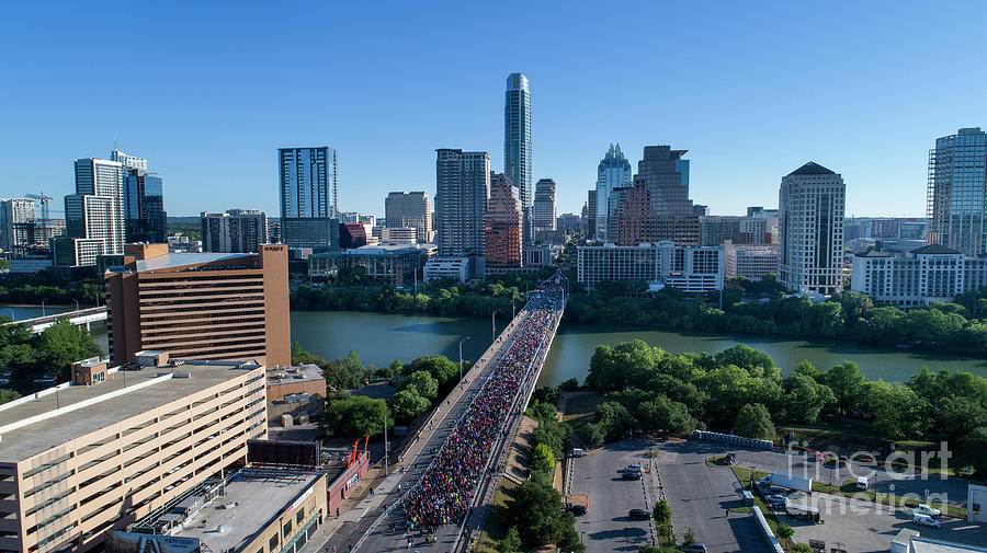 Austin Photograph - Birds eye aerial view as thousands of runners fill up the Congress Avenue Bridge during the Statesman Cap10K in downtown Austin Texas by Dan Herron