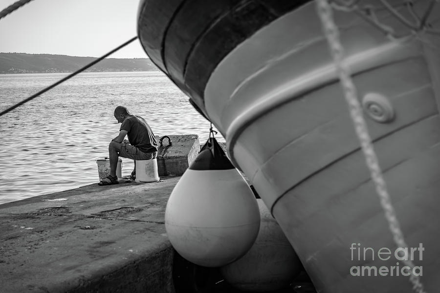 Black And White Photograph - Black and White - Fisherman cleaning fish on docks of Kastel Gomilica, Split Croatia by Global Light Photography - Nicole Leffer