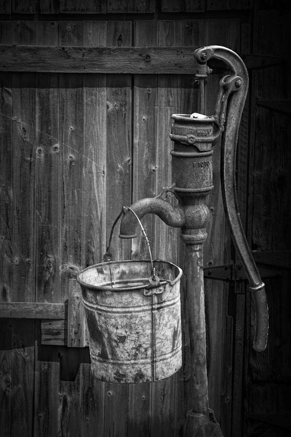 Architecture Photograph - Black and White Still Life of Rusty Water Pump with Bucket by Randall Nyhof