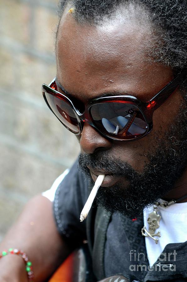 Black male busker with sunglasses cigarette and skull pendant London England Photograph by Imran Ahmed