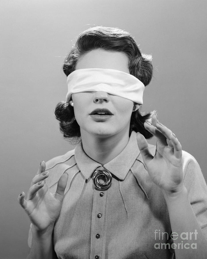 blindfolded woman sitting at a table - SuperStock