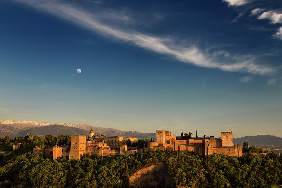 Blue sky and moon over hilltop Alhambra Palace fortress complex