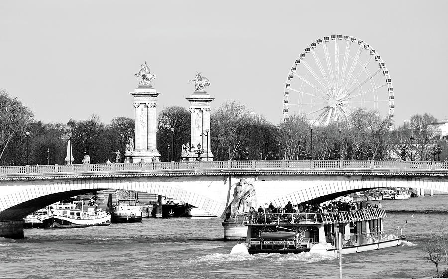 Boat Passing Under Pont Des Invalides with Pont Alexandre Columns and Roue de Paris Black and White Photograph by Shawn OBrien
