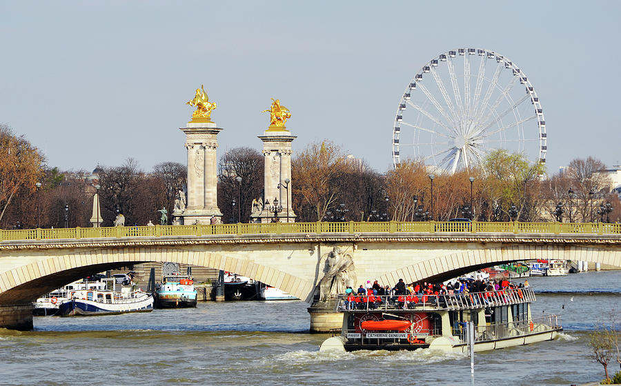 Boat Passing Under Pont Des Invalides with Pont Alexandre Columns and Roue de Paris Photograph by Shawn OBrien