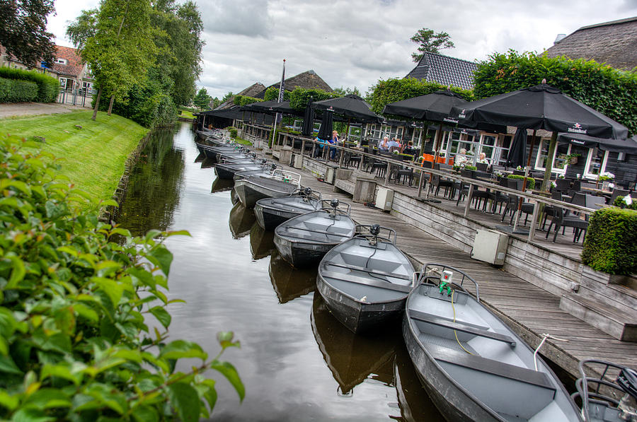 Boats parked in canal, Giethoorn, the Netherlands Photograph by Joan Baker