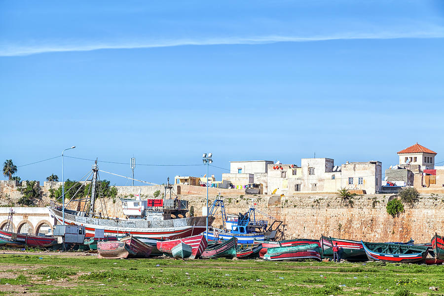 boats were repaired in front of the walls of the old historic portuguese fortress city El Jadida in  Photograph by Gina Koch