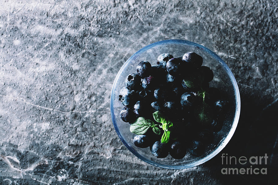 Nature Photograph - Bowl of juicy blueberries with a green leaf by Michal Bednarek