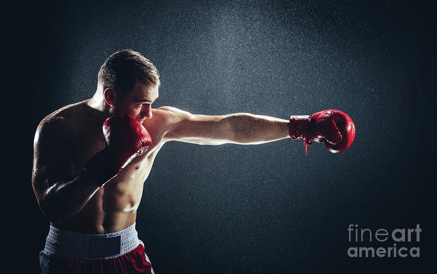 Boxer striking a blow in the rain. Photograph by Michal Bednarek