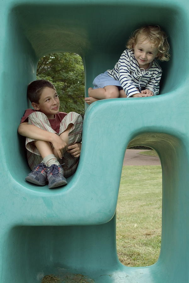 Boy and girl playing in plastic cube Photograph by Sami Sarkis