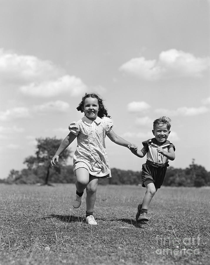 Boy And Girl Running Through Field Photograph by H. Armstrong Roberts/ClassicStock