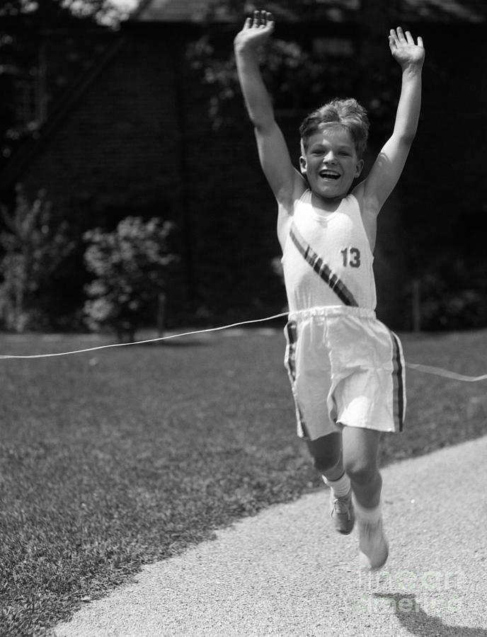 Boy In Track Uniform Crossing Finish Photograph by H. Armstrong Roberts/ClassicStock