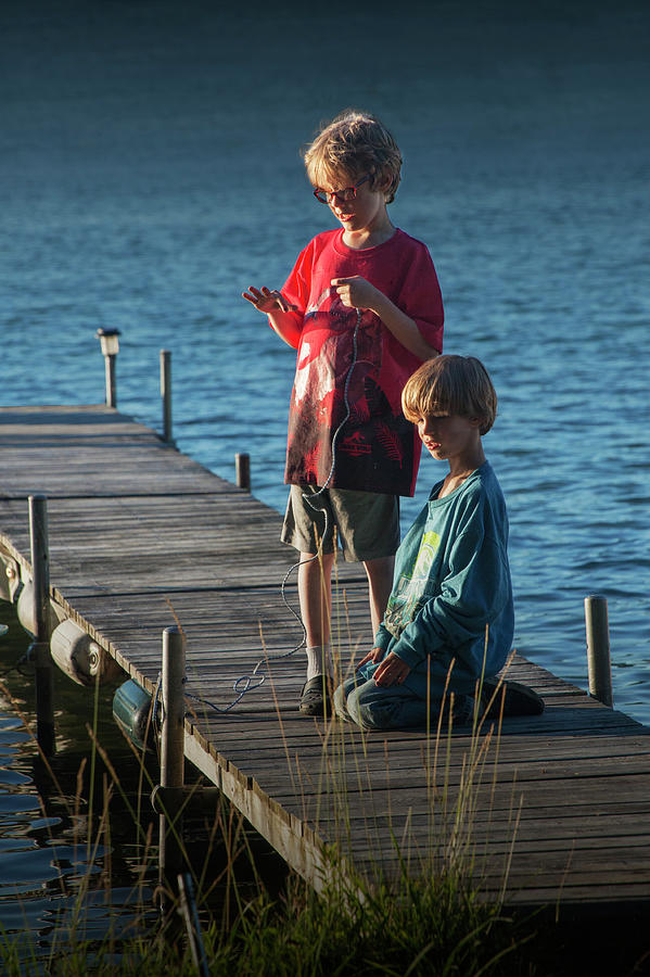 Boys on a Wooden Boat Dock in Late Afternoon Photograph by Randall Nyhof