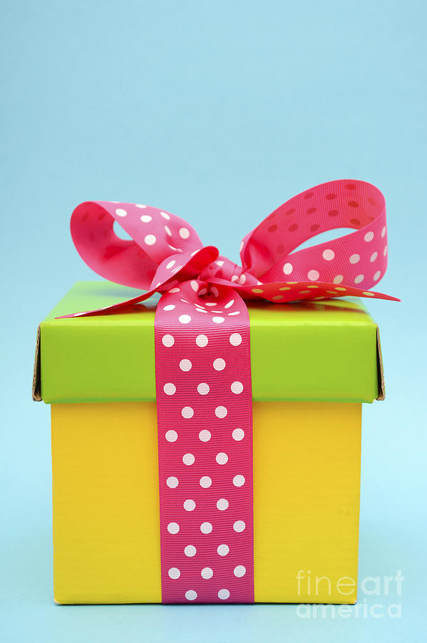 Christmas Photograph - Bright color gift box on pink and blue background.  by Milleflore Images