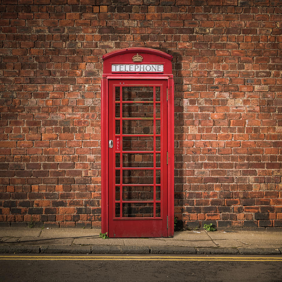 London Photograph - British Phone Box Against Red Brick Wall by Mr Doomits