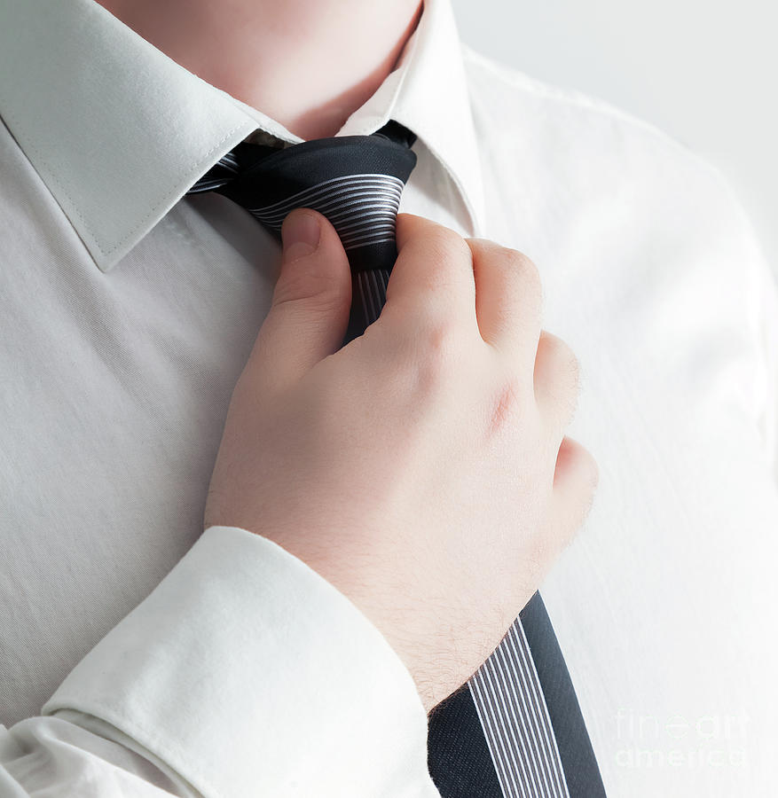 Businessman adjusting his tie, close-up Photograph by Michal Bednarek