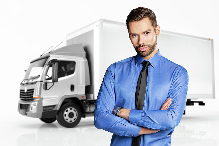 Businessman standing in front of a truck. Photograph by Michal Bednarek