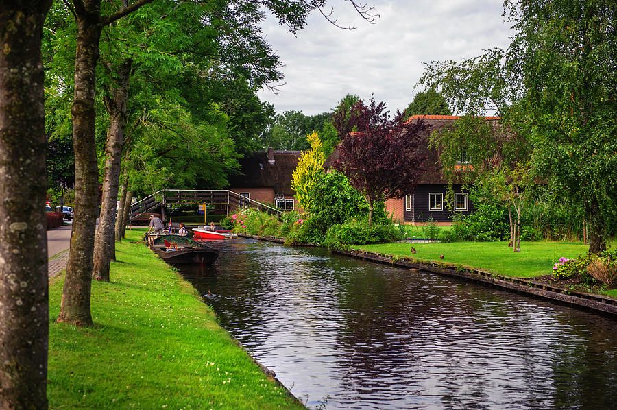 Canal in Giethoorn with boats Photograph by Jenny Rainbow