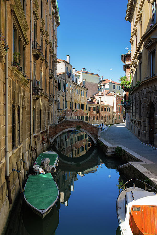 Canal with boats and blue water in lovely Venice Italy Photograph by Matthias Hauser