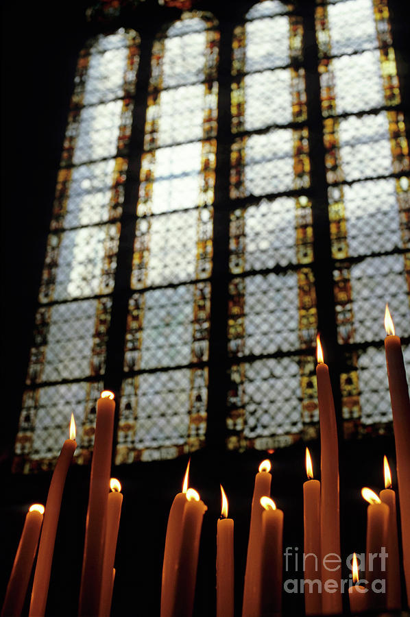 Candles burning in front of a stained glass window in the Auch Cathedral Photograph by Sami Sarkis