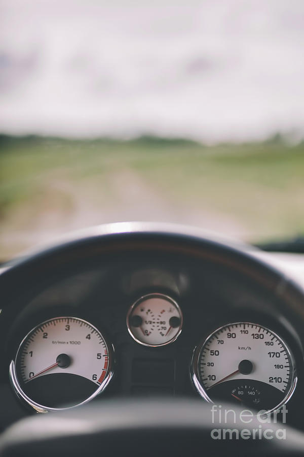 Car cockpit and a dirt road in the field. Photograph by Michal Bednarek
