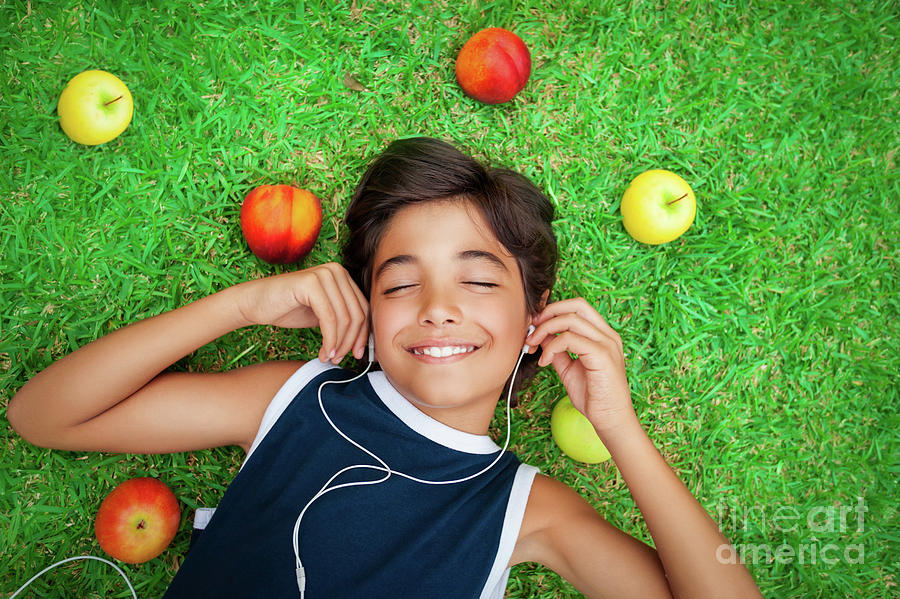 Cheerful boy listening to music Photograph by Anna Om