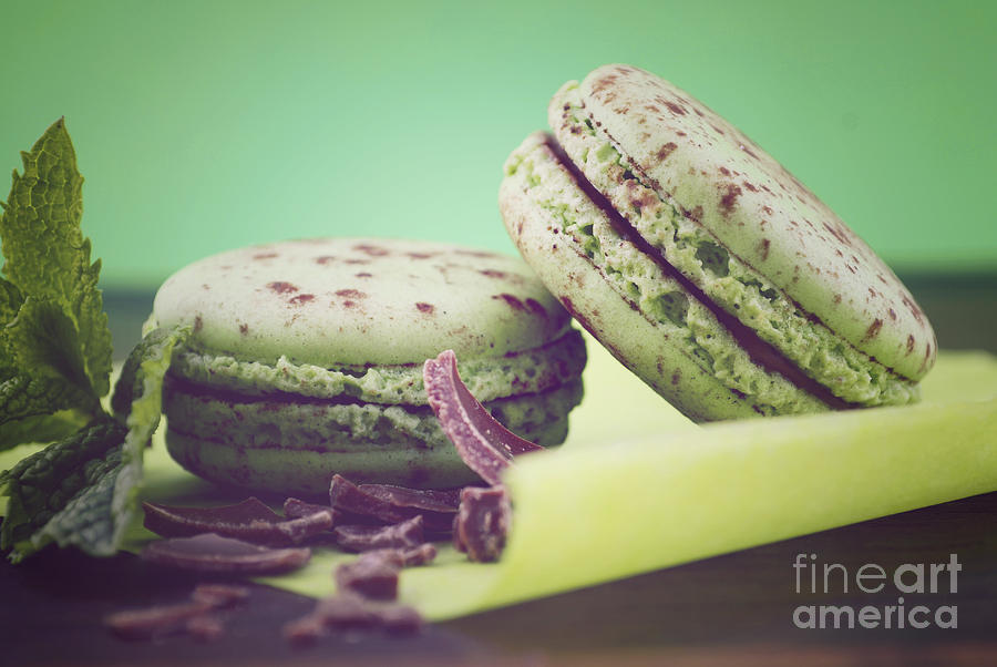 Chocolate and mint flavor macaroons on dark wood table Photograph by Milleflore Images