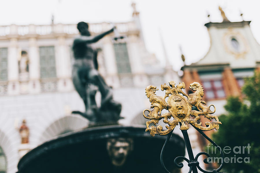 City crest of Gdansk and blurred Neptune statue. Photograph by Michal Bednarek