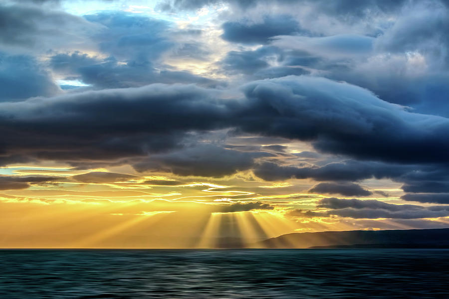 Clouds, sun rays and water Photograph by Maria Coulson