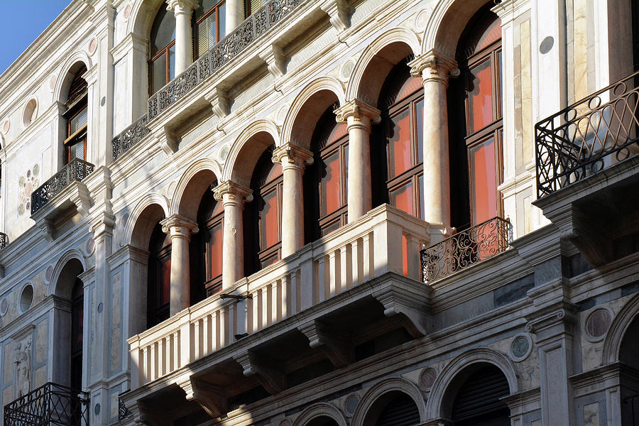 Classical Italian marble building facade with columns arches and balcony by Oana Unciuleanu