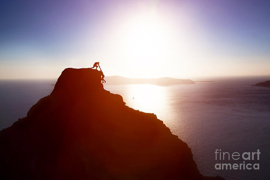 Sunset Photograph - Climber giving hand and helping his friend to reach the top of the mountain by Michal Bednarek