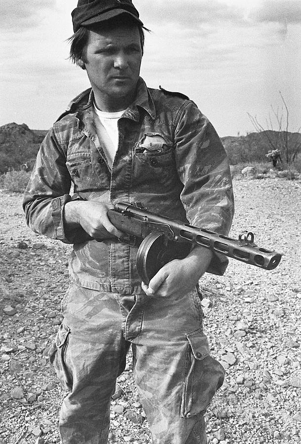 Close up of Barry Sadler shooting another type of his numerous  machine guns  Tucson  Arizona 1971. Photograph by David Lee Guss