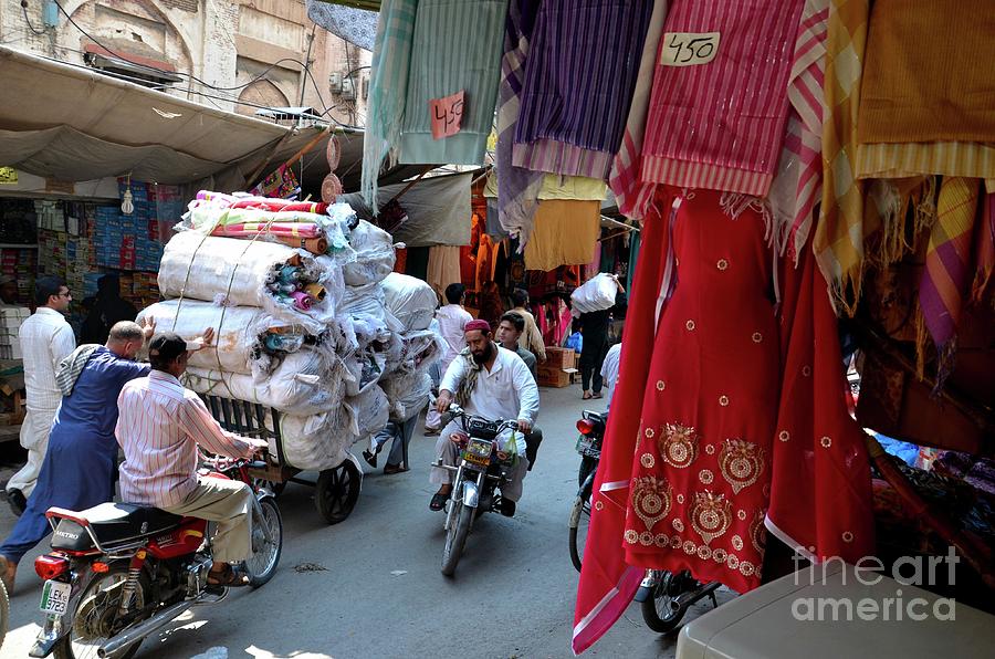 Motorcycle Photograph - Cloth shops inside traditional bazaar market in walled city Lahore Pakistan by Imran Ahmed