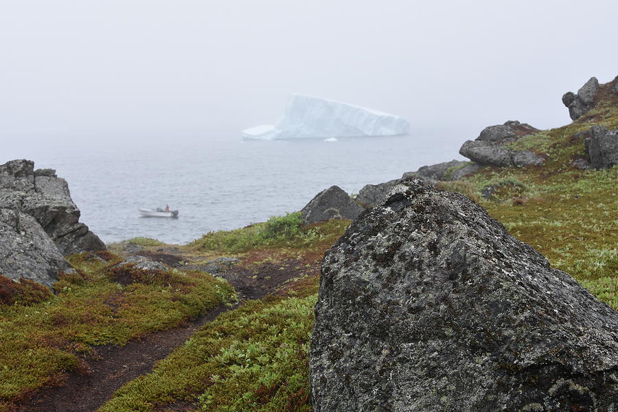 Coastal trail in Newfoundland with iceberg and fishing boat in the