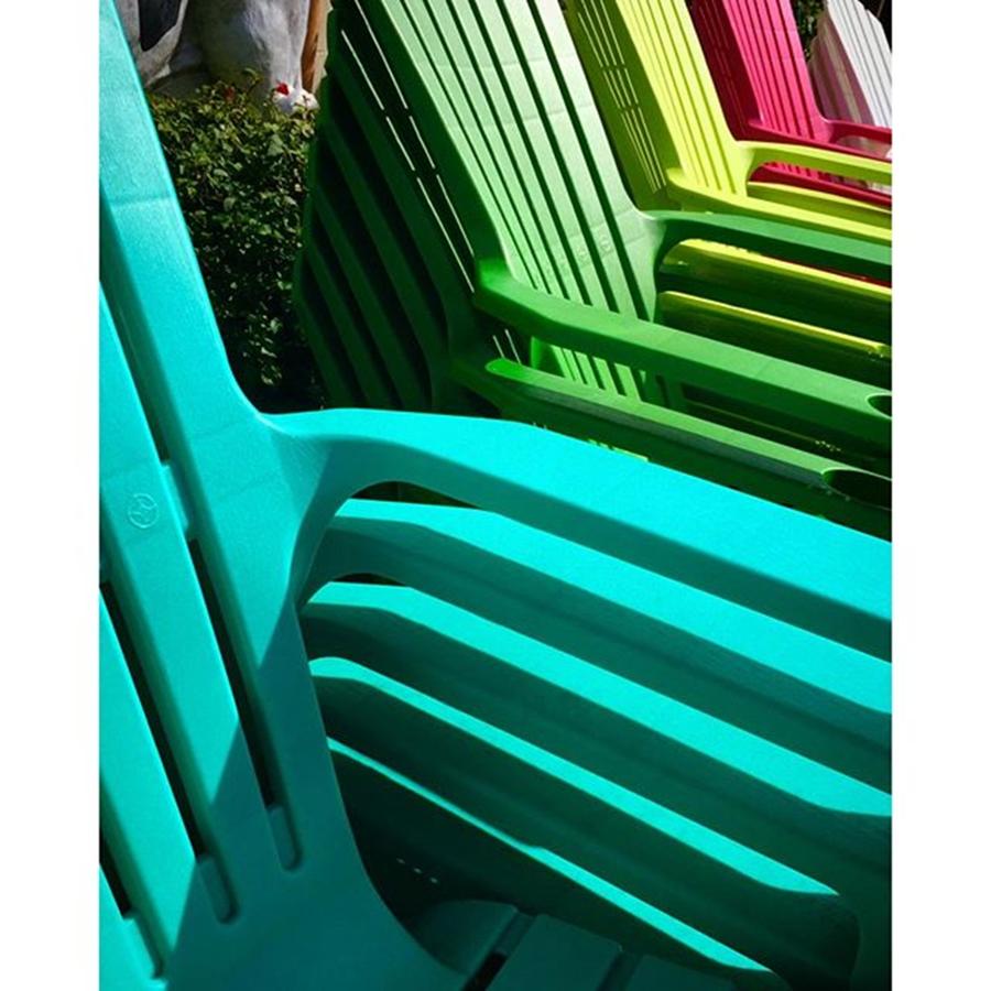 Chair Photograph - Colorful Stacked Plastic Chairs In by Juan Silva