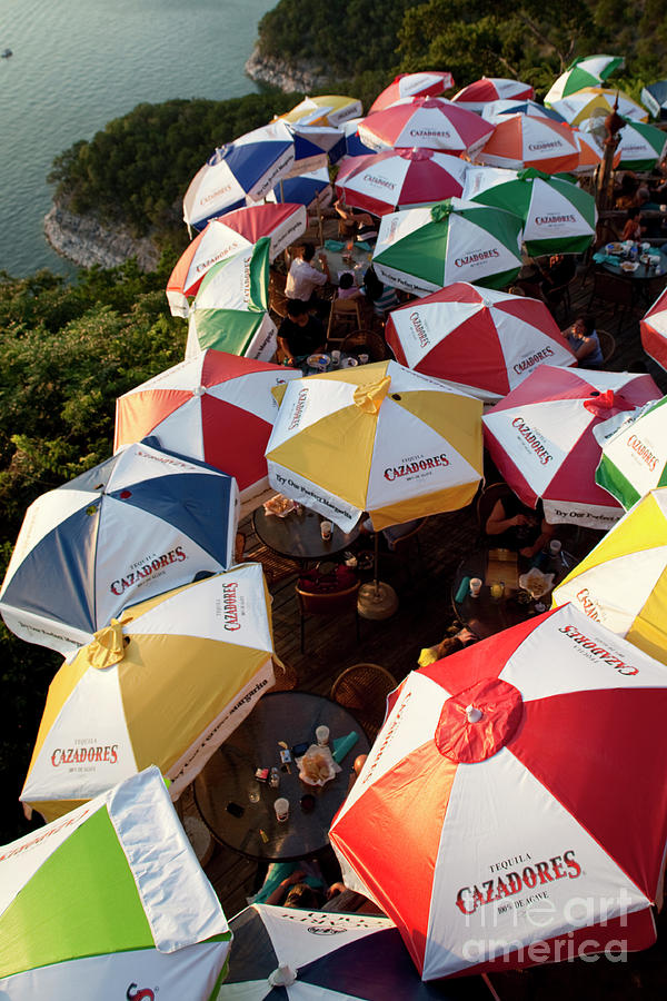 Sunset Photograph - Colorful umbrellas shade Lake Travis Restaurant by Dan Herron